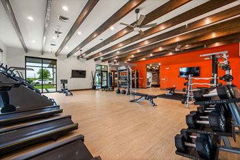 A gym with treadmills, weights, and exercise equipment.